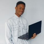 Handsome black man standing on a blue wall _ Free Photo